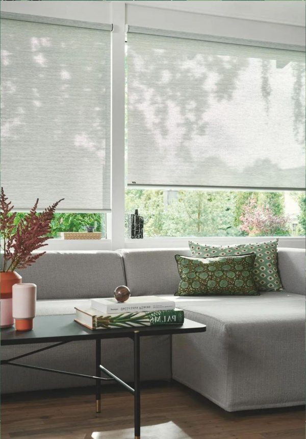 Motorized roller blinds with tubular motor installed in modern window for indoor shading